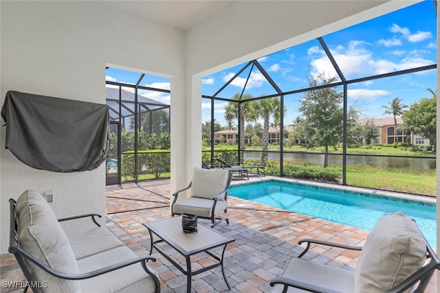 pool featuring a patio area, a water view, and a lanai