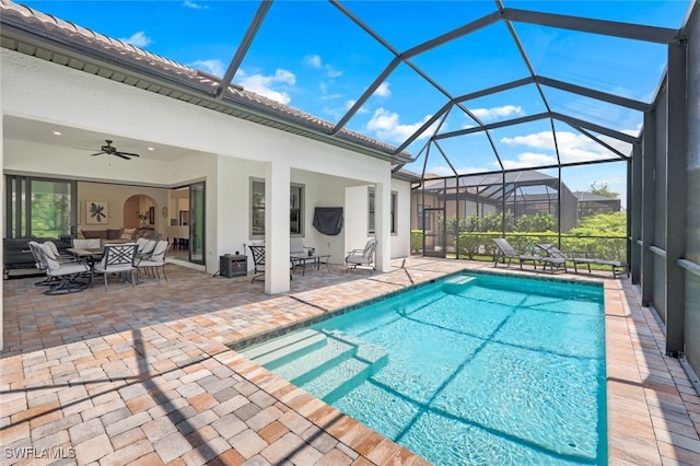 pool featuring a ceiling fan, glass enclosure, a patio area, and an outdoor living space