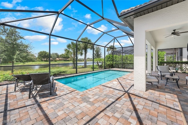 pool with glass enclosure, a water view, and a patio