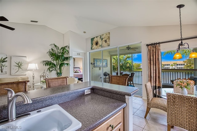 kitchen featuring light tile patterned flooring, vaulted ceiling, pendant lighting, ceiling fan, and sink