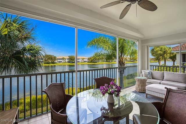 sunroom / solarium with lofted ceiling, a water view, and ceiling fan