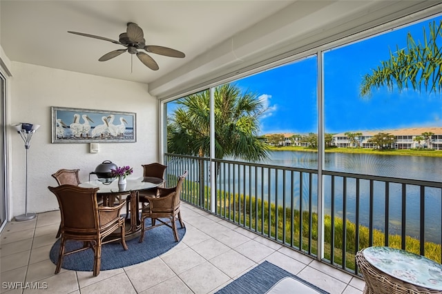 sunroom / solarium featuring a water view and ceiling fan