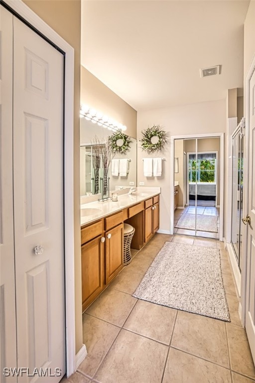 bathroom with vanity, a shower with door, and tile patterned floors