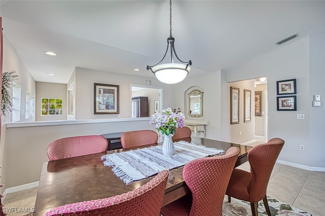 tiled dining room with lofted ceiling