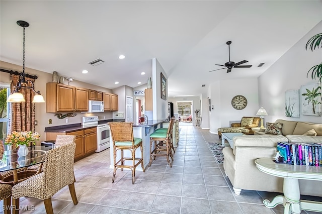 kitchen with white appliances, light tile patterned floors, lofted ceiling, ceiling fan, and decorative light fixtures