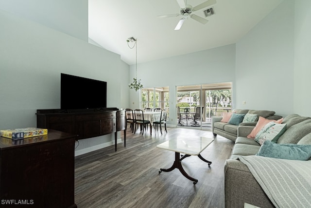 living room featuring dark wood-type flooring, ceiling fan with notable chandelier, and high vaulted ceiling