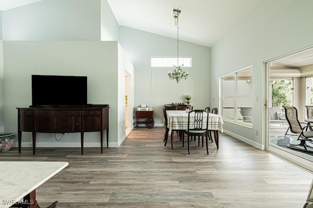 25202 Golf Lake Cir, Bonita Springs, FL 34135 - dining space with baseboards, high vaulted ceiling, wood finished floors, and an inviting chandelier