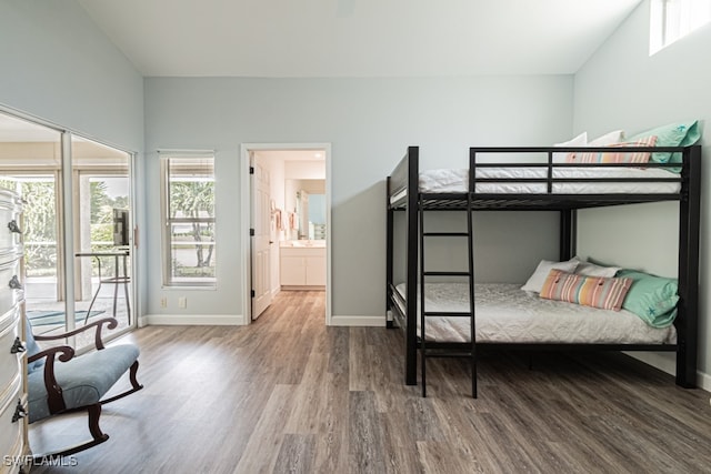 bedroom with lofted ceiling, hardwood / wood-style flooring, ensuite bathroom, and access to outside