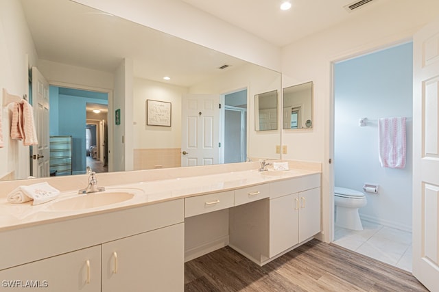 bathroom featuring vanity, toilet, hardwood / wood-style flooring, and an enclosed shower