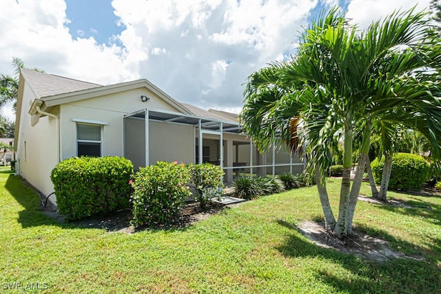 view of home's exterior with a lawn and a lanai