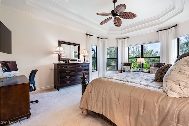 carpeted bedroom with a raised ceiling, ceiling fan, and ornamental molding