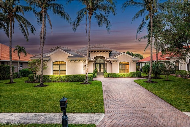 mediterranean / spanish-style home featuring french doors and a yard