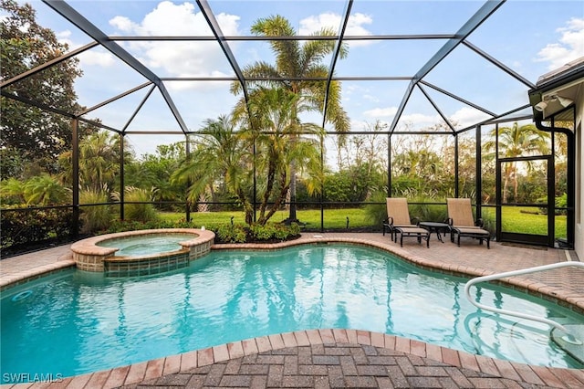 view of pool featuring a patio, glass enclosure, and an in ground hot tub