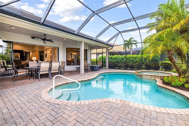 view of swimming pool with ceiling fan, a lanai, an in ground hot tub, and a patio area