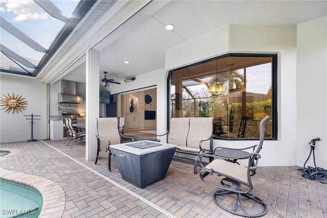 view of patio featuring ceiling fan and glass enclosure