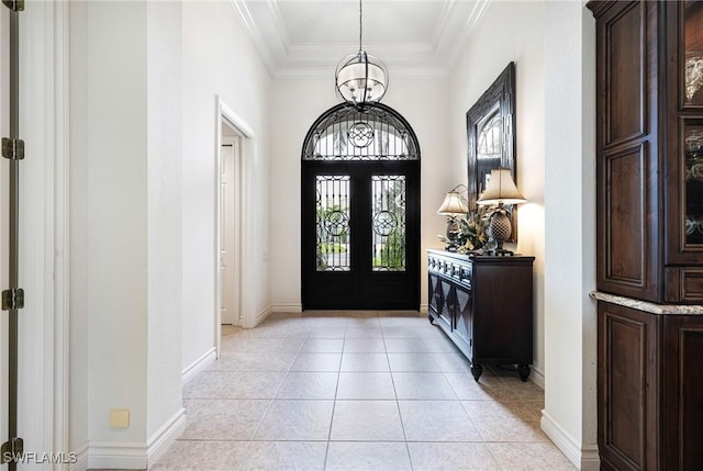 foyer with french doors, an inviting chandelier, crown molding, and light tile patterned floors