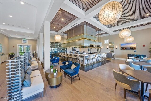 interior space with a high ceiling, light hardwood / wood-style flooring, coffered ceiling, and beam ceiling