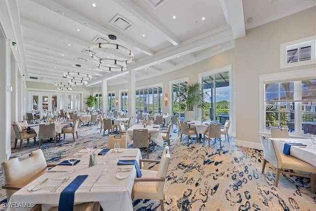 dining room with a towering ceiling, visible vents, baseboards, french doors, and beamed ceiling