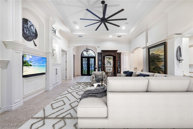 living room featuring a towering ceiling, french doors, a raised ceiling, and ceiling fan