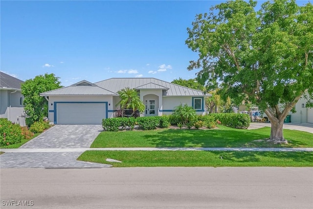 single story home with decorative driveway, a standing seam roof, metal roof, a garage, and a front lawn