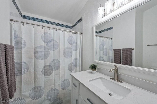 bathroom featuring vanity and curtained shower