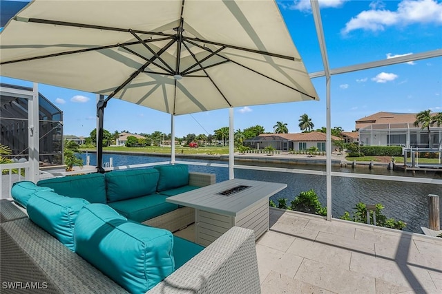 view of patio / terrace with glass enclosure, a water view, and an outdoor living space with a fire pit