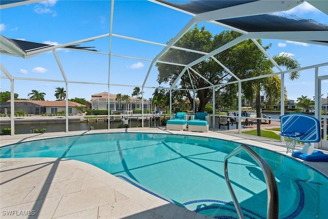 pool featuring glass enclosure, a patio, and a water view