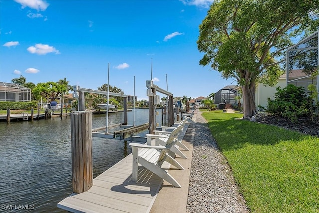 view of dock with a water view, boat lift, a residential view, and a lawn