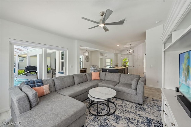 living area featuring lofted ceiling, light wood-style flooring, recessed lighting, a ceiling fan, and baseboards