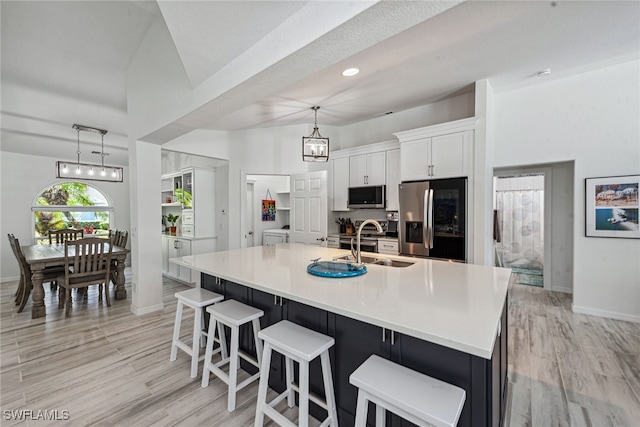 kitchen with a spacious island, stainless steel appliances, light wood-type flooring, and white cabinets