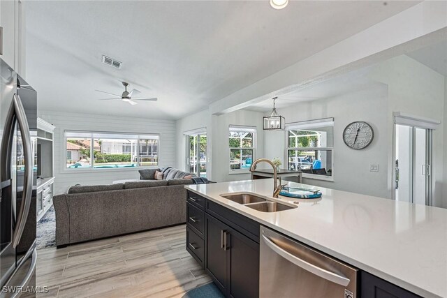 kitchen with appliances with stainless steel finishes, plenty of natural light, sink, and ceiling fan