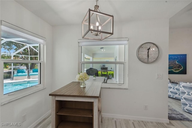 dining room featuring an inviting chandelier, baseboards, and wood finished floors