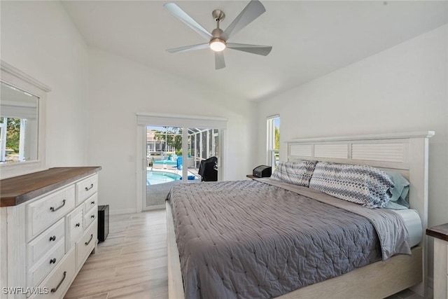 bedroom featuring lofted ceiling, multiple windows, light wood-type flooring, and access to exterior