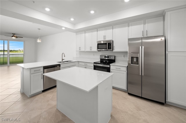 kitchen featuring pendant lighting, sink, ceiling fan, appliances with stainless steel finishes, and kitchen peninsula