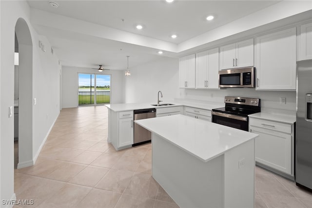 kitchen featuring ceiling fan, kitchen peninsula, decorative light fixtures, a kitchen island, and appliances with stainless steel finishes