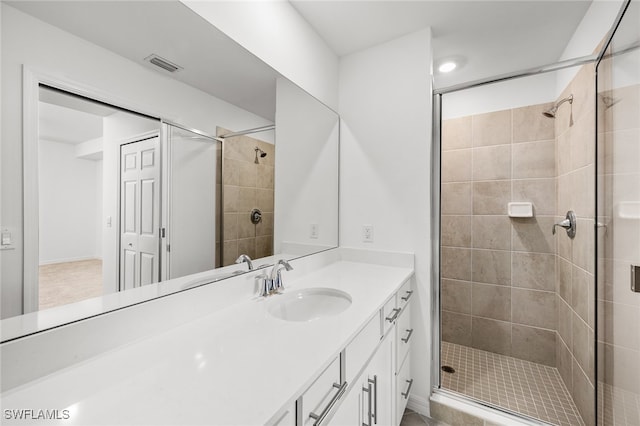 bathroom with vanity and a shower with shower door