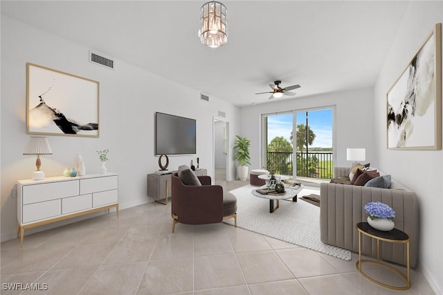 living room featuring ceiling fan with notable chandelier and light tile patterned floors