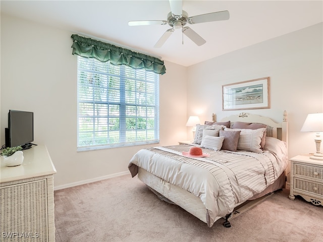 carpeted bedroom featuring ceiling fan and multiple windows