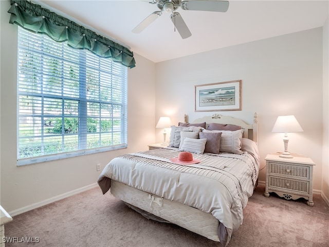 carpeted bedroom featuring multiple windows and ceiling fan