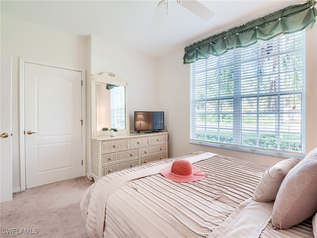 carpeted bedroom featuring ceiling fan and multiple windows