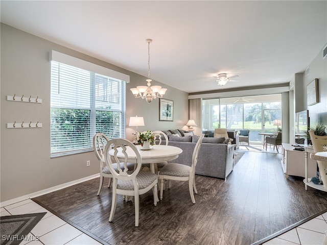 dining space with ceiling fan with notable chandelier and hardwood / wood-style floors