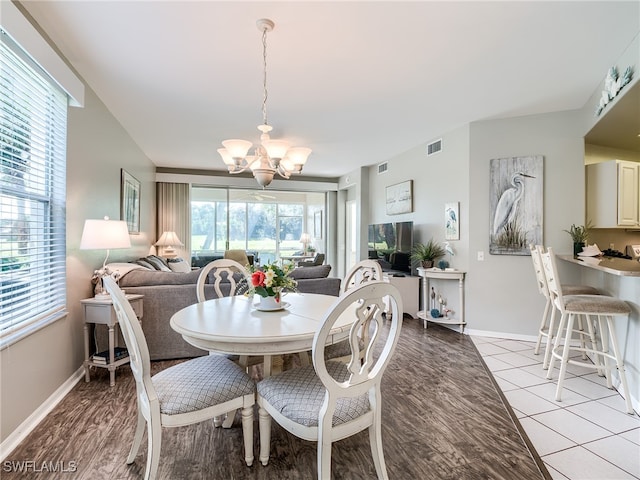 tiled dining space with a notable chandelier