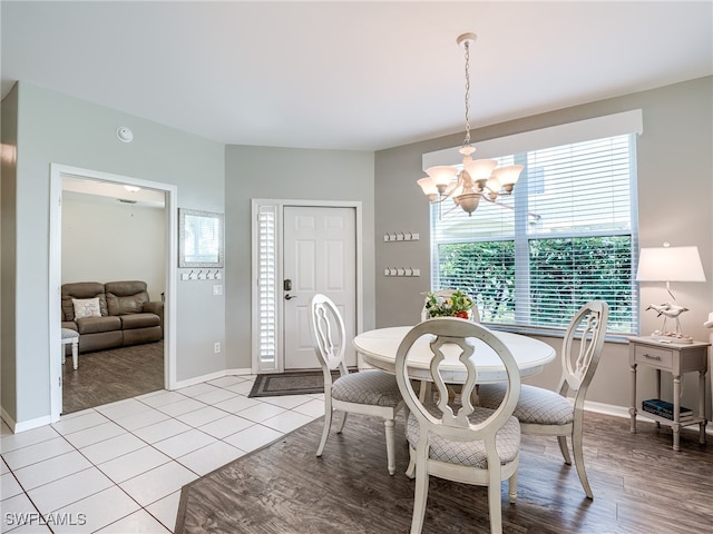 dining area with light hardwood / wood-style flooring and a notable chandelier