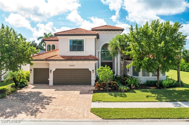 mediterranean / spanish home with a front lawn and a garage