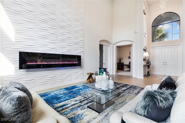 living room with a towering ceiling and tile patterned flooring