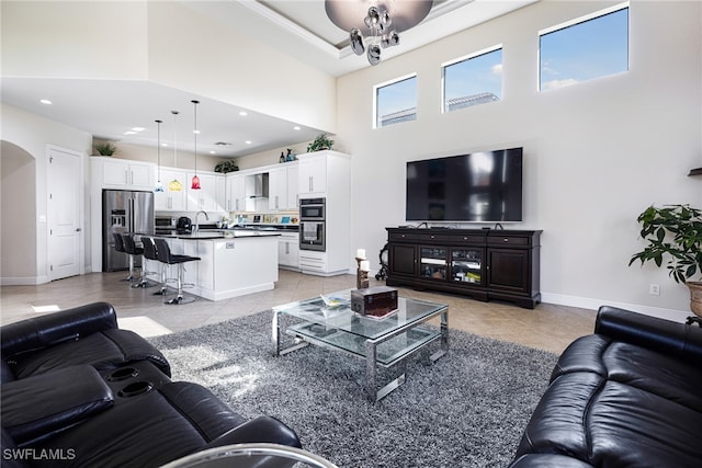 living room with a towering ceiling and light tile patterned floors