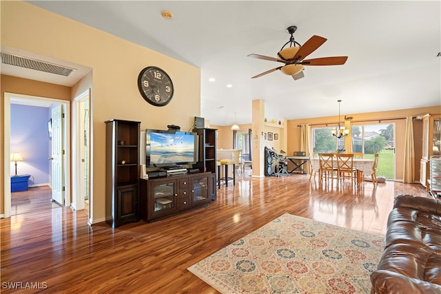 living room featuring ceiling fan with notable chandelier and hardwood / wood-style floors