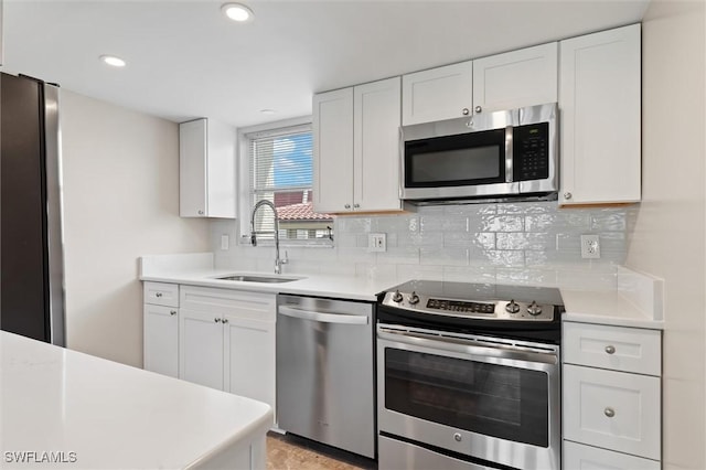 kitchen featuring white cabinetry, stainless steel appliances, sink, and tasteful backsplash