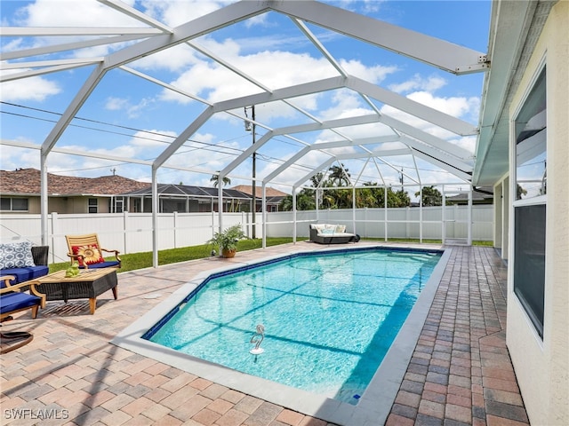 view of swimming pool featuring a lanai and a patio