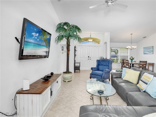 living room with light tile patterned floors, vaulted ceiling, and ceiling fan with notable chandelier